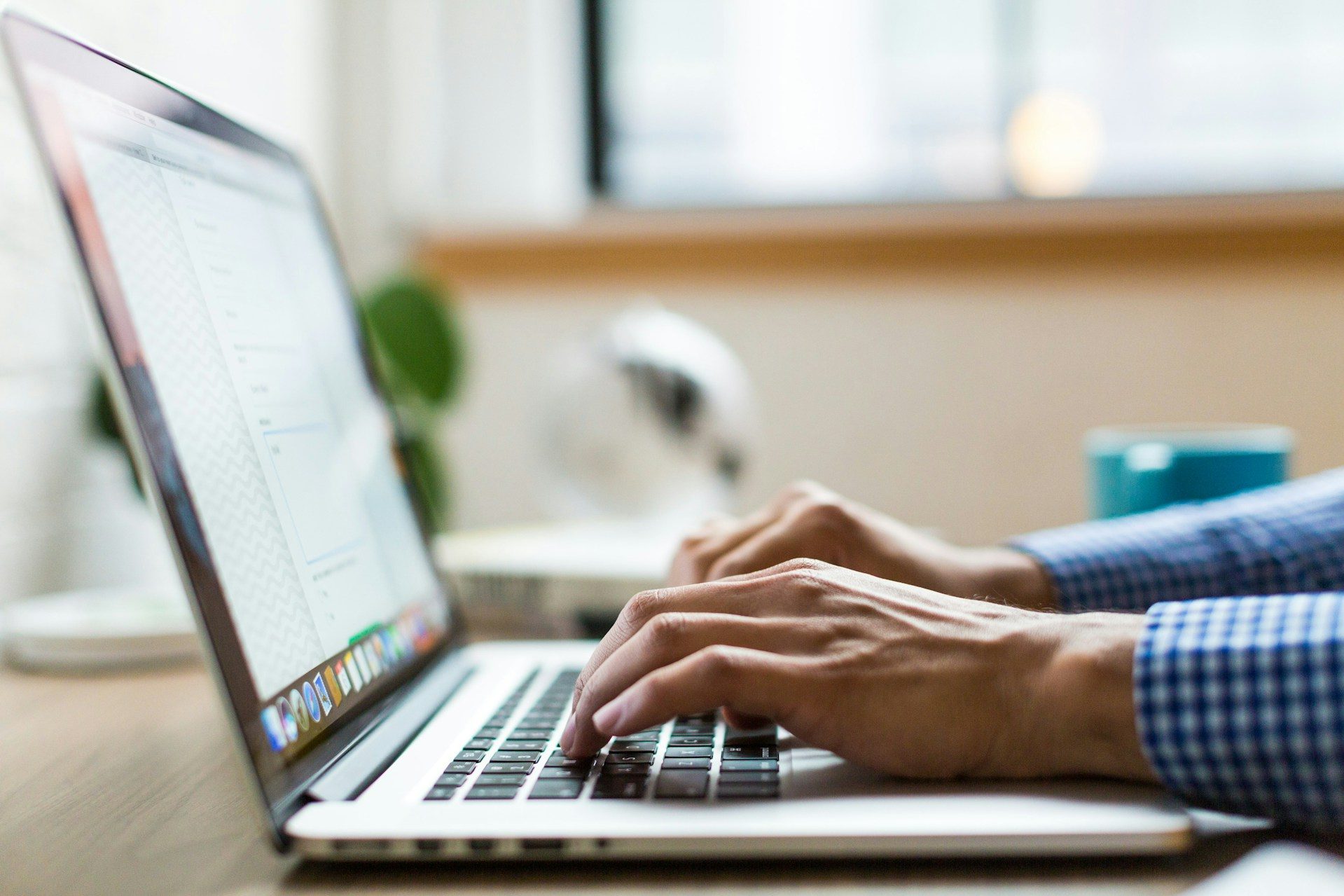 Image of someone writing on a laptop